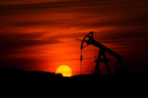 Image of a fracking pump in front of a smoky sunset